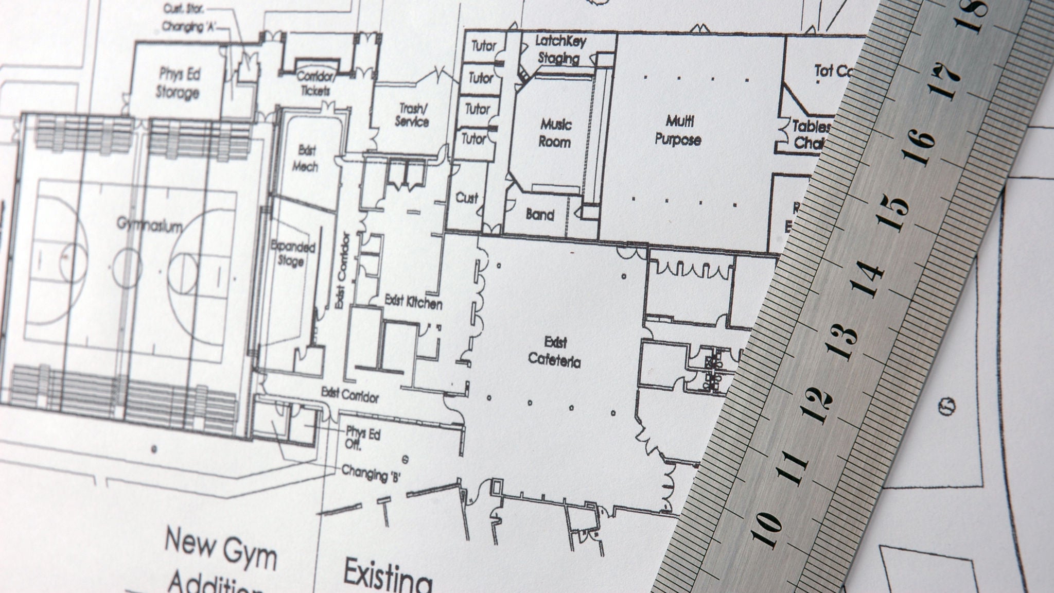 Architectural drawings for proposed school redevelopment with a steel ruler.